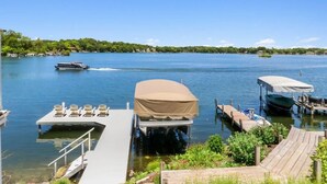 A lakeside dock with boats, a covered RV, and a row of chairs. - The Mill-Lauderdale Lakes Getaway |Breathtaking Views |Kayaks |15 Minutes to Skiing |Pier |Firepit (Elkhorn)