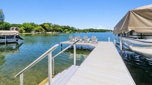 A dock with a covered seating area and a boat. - The Mill-Lauderdale Lakes Getaway |Breathtaking Views |Kayaks |15 Minutes to Skiing |Pier |Firepit (Elkhorn)