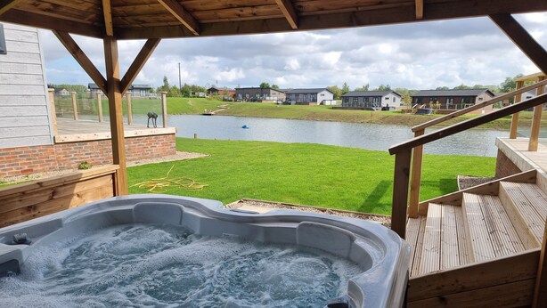 Ein Whirlpool mit Blick auf einen See und Häuser im Hintergrund.