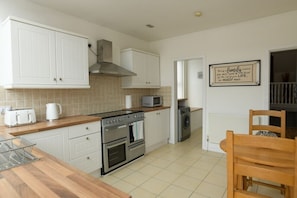 Kitchen with oven, microwave, and sink, plus a dining area with a table and chairs.