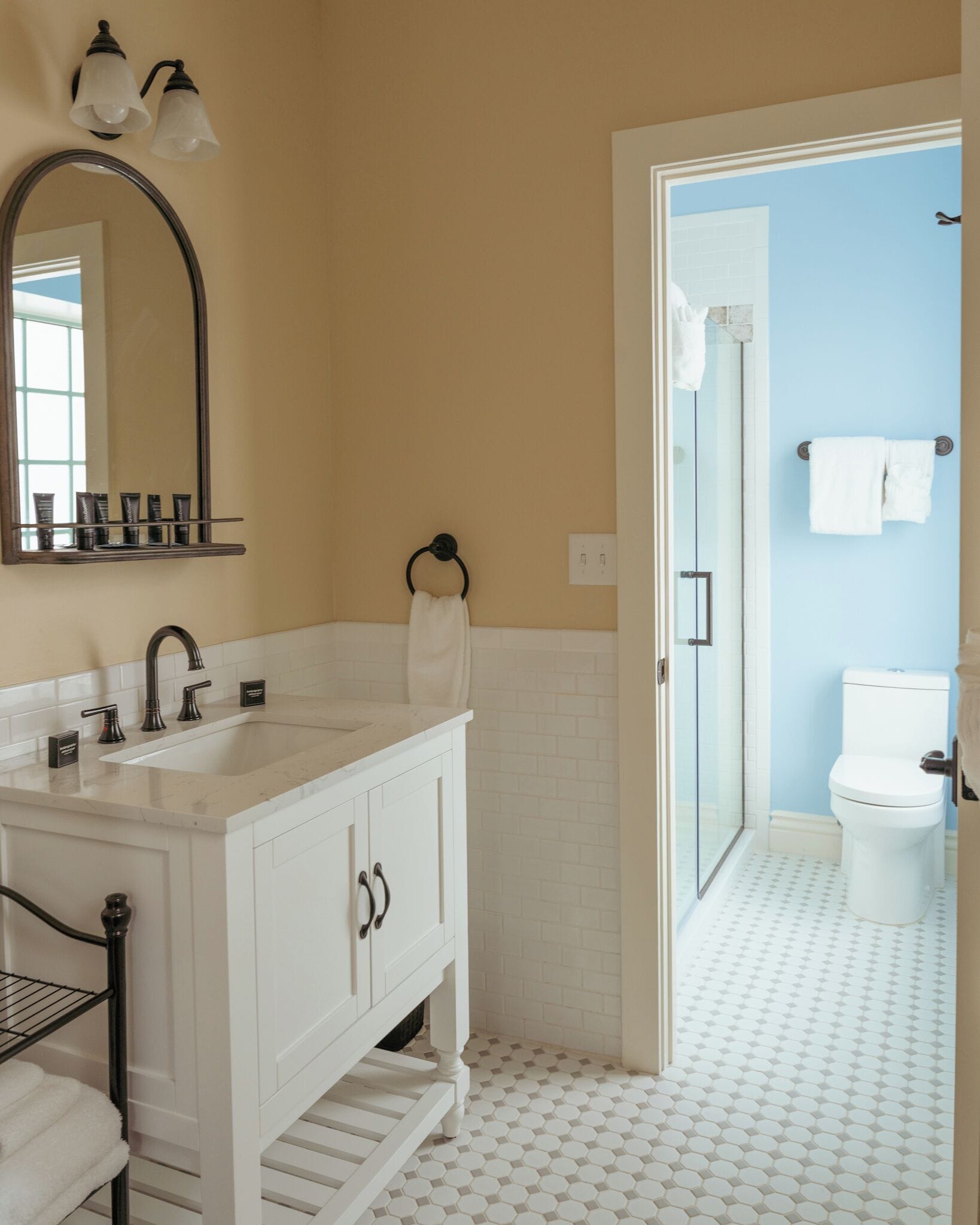 A bathroom with a white vanity, a large mirror, and a shower area.