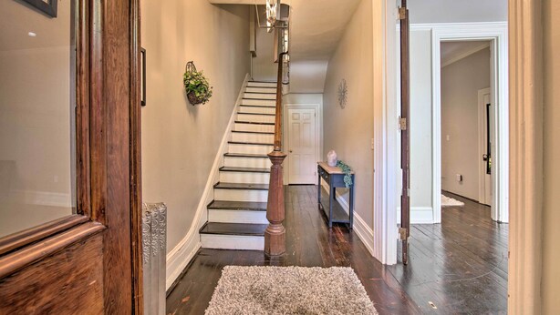 A staircase with a wooden handrail and a light fixture above it. - 1 Mi to Dtwn: Historic Harrisburg Home (Harrisburg)
