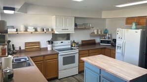 A modern kitchen with white cabinets, a wooden countertop, a built-in oven, a microwave, and a refrigerator. - Family suite sleeps 11!  We are near Champaign-Urbana 4 bedrooms & 2.5 bathrooms (Saint Joseph)