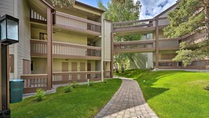 Un immeuble à plusieurs étages doté de balcons, d’une allée pavée et d’un espace verdoyant.