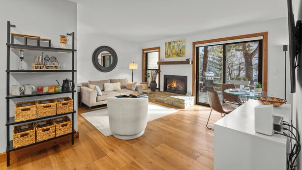 Un salon moderne avec une cheminée, un canapé, une table basse et un coin repas doté d’une table en verre.