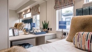 A bedroom with a bed, bedside table, and a window with curtains. - Briargate, Aldeburgh (Aldeburgh)