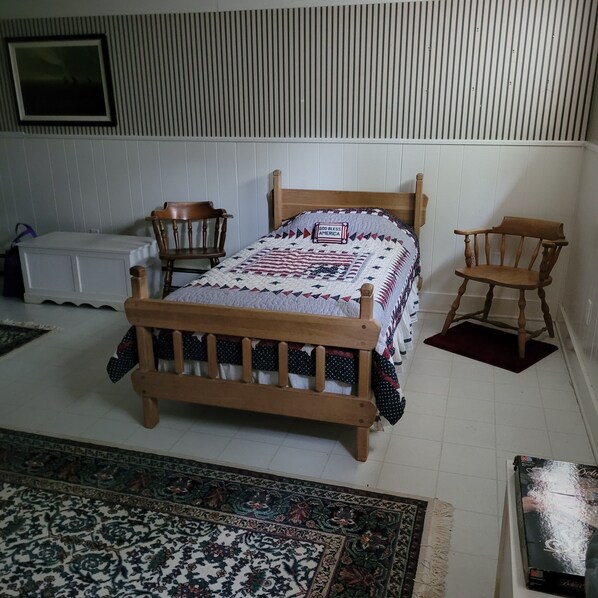 A bedroom with a wooden bed, two wooden chairs, a white dresser, and a patterned rug. - Quiet cul-de-sac on 18-hole golf course. Good neighbors. (Rapid City)