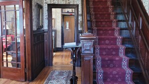 A grand staircase with a patterned carpet leading to a door.