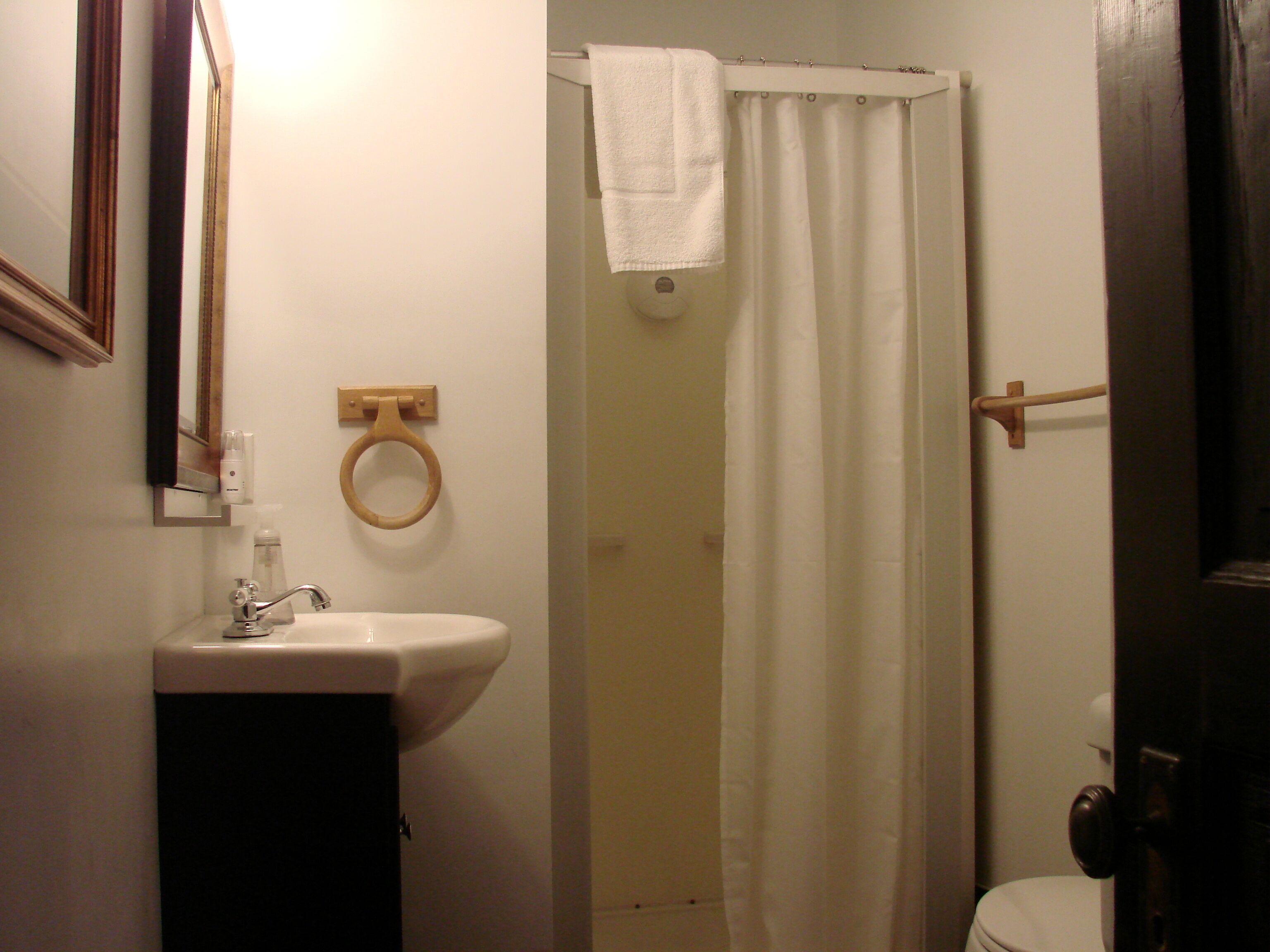 A bathroom with a sink, toilet, and shower curtain.