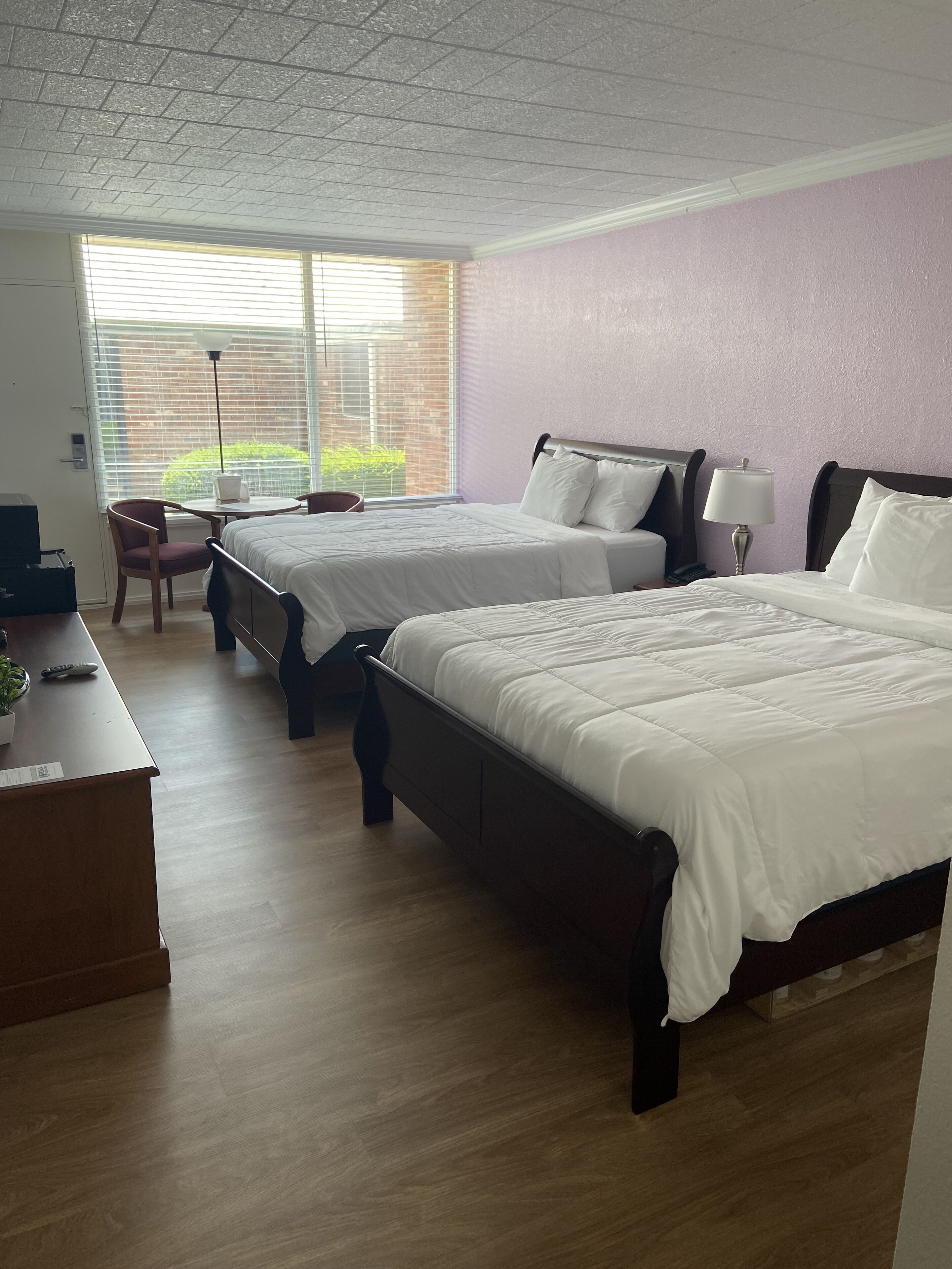 Habitación de hotel con dos camas, un escritorio y una silla.