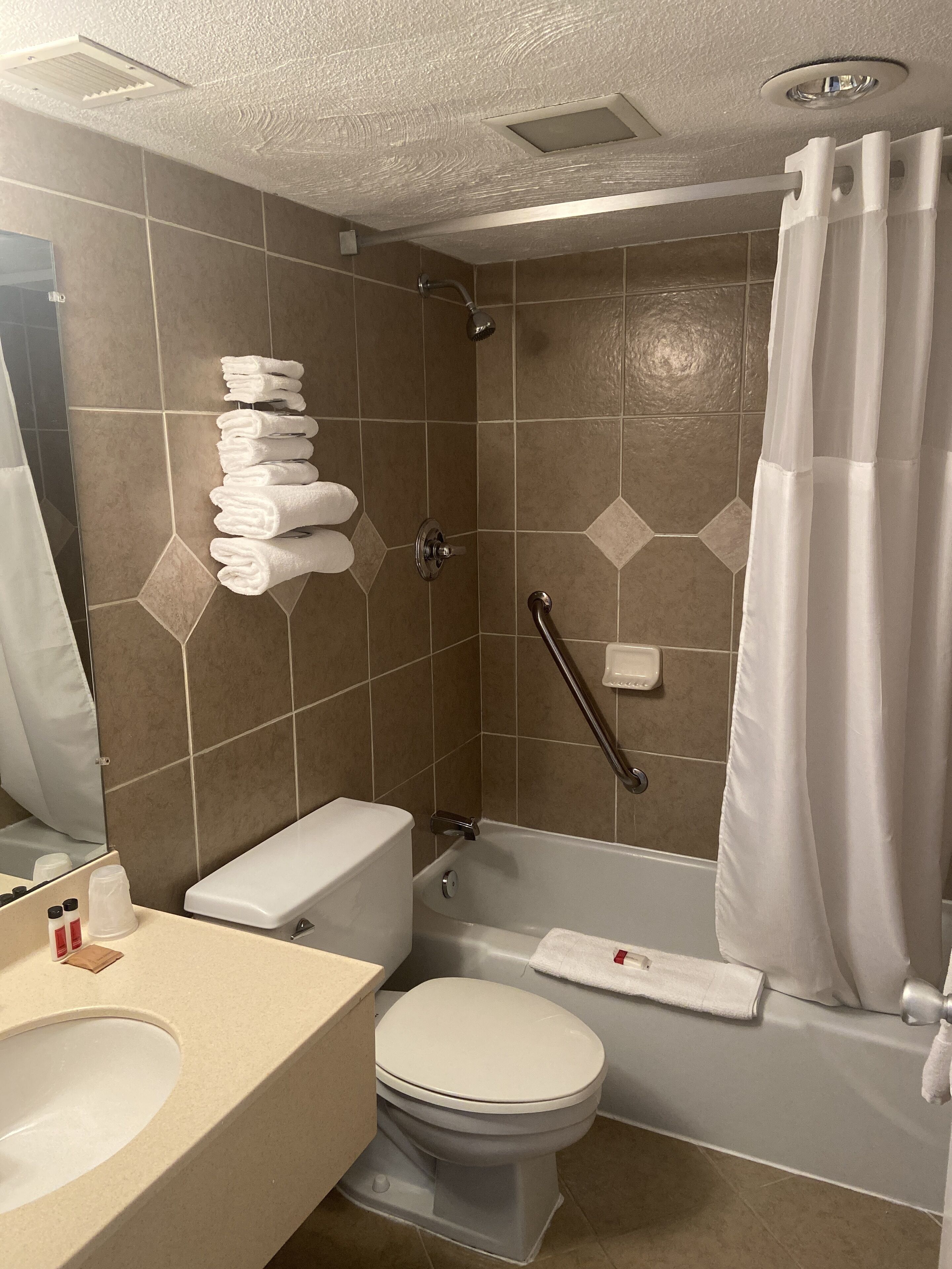 A bathroom with a toilet, sink, and shower.