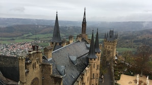 A historic building with multiple spires and a prominent clock tower, surrounded by a town and hilly landscape. - 3,5 Zimmer Ferienwohnung am Fuße der Schwäbischen Alb Balingen (Balingen)
