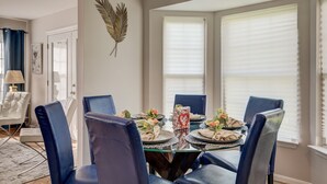 A dining area with a round glass table, blue upholstered chairs, and a decorative wall piece. - Close to DC excellent location (Temple Hills)