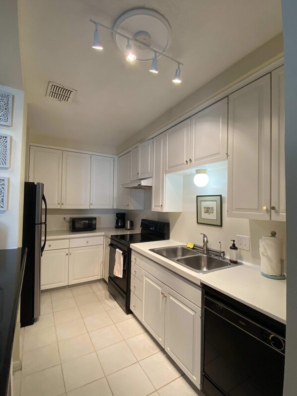 Enjoy cooking and dining in this well-equipped kitchen with a sink, dishwasher, microwave, oven, and coffee maker.