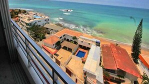 A coastal view with buildings, a clear sky, and a calm sea.