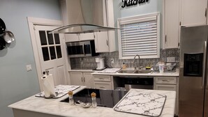 A modern kitchen with a central island, stainless steel appliances, and a backsplash with geometric patterns. - Classic Build with modern decor (Chattanooga)