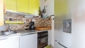 A kitchen with a sink, stove, and various utensils. - Le Mirador - Studio avec balcon Vue Lac et Montagnes (Embrun)