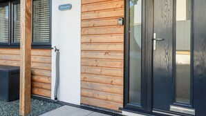 Un edificio con fachada de madera, puerta de cristal y una placa con el nombre "Clonmore".