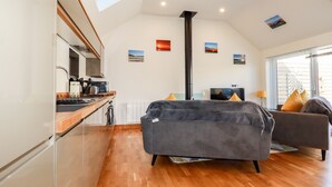 Un interior moderno con cocina, sofá y televisión.