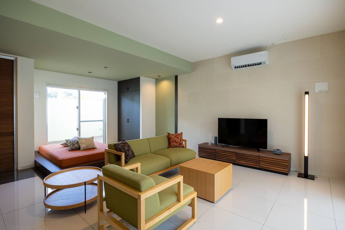 Una sala moderna con sofá, mesa de centro y televisor.