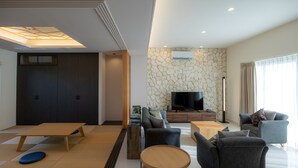 A modern living room with a sofa set, a coffee table, and a TV. - YUMIHA OKINAWA (Onna)