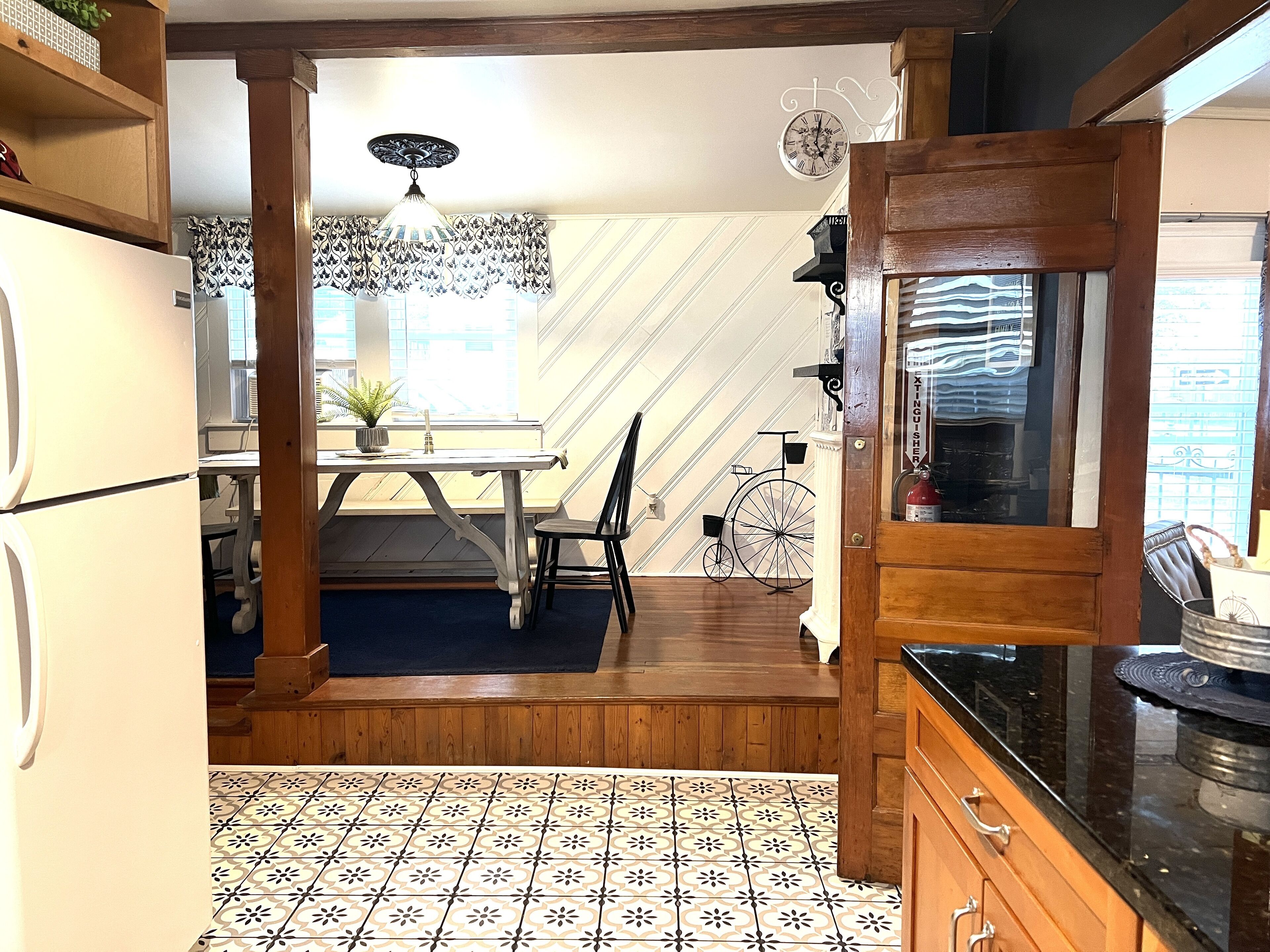 A kitchen with a dining area, a wooden staircase, and a bicycle.