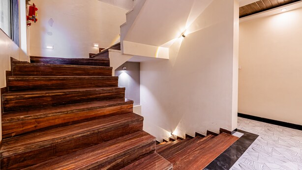 A wooden staircase with a black and white patterned floor. - Itsy Hotels Golden Birds (Navi Mumbai)