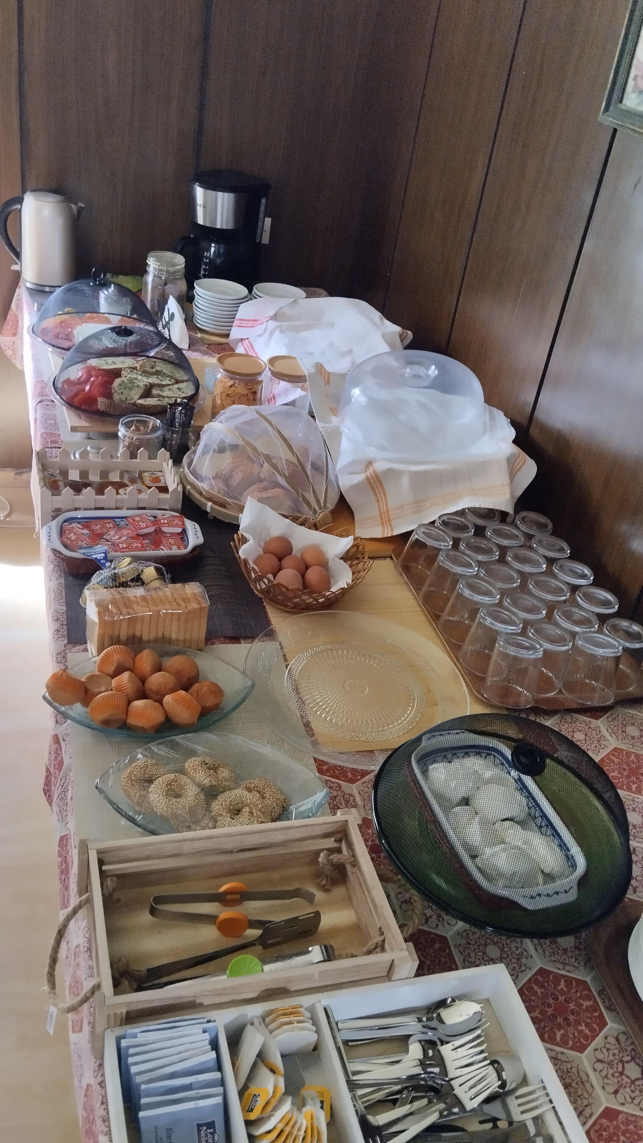 A buffet table with various food items and utensils.