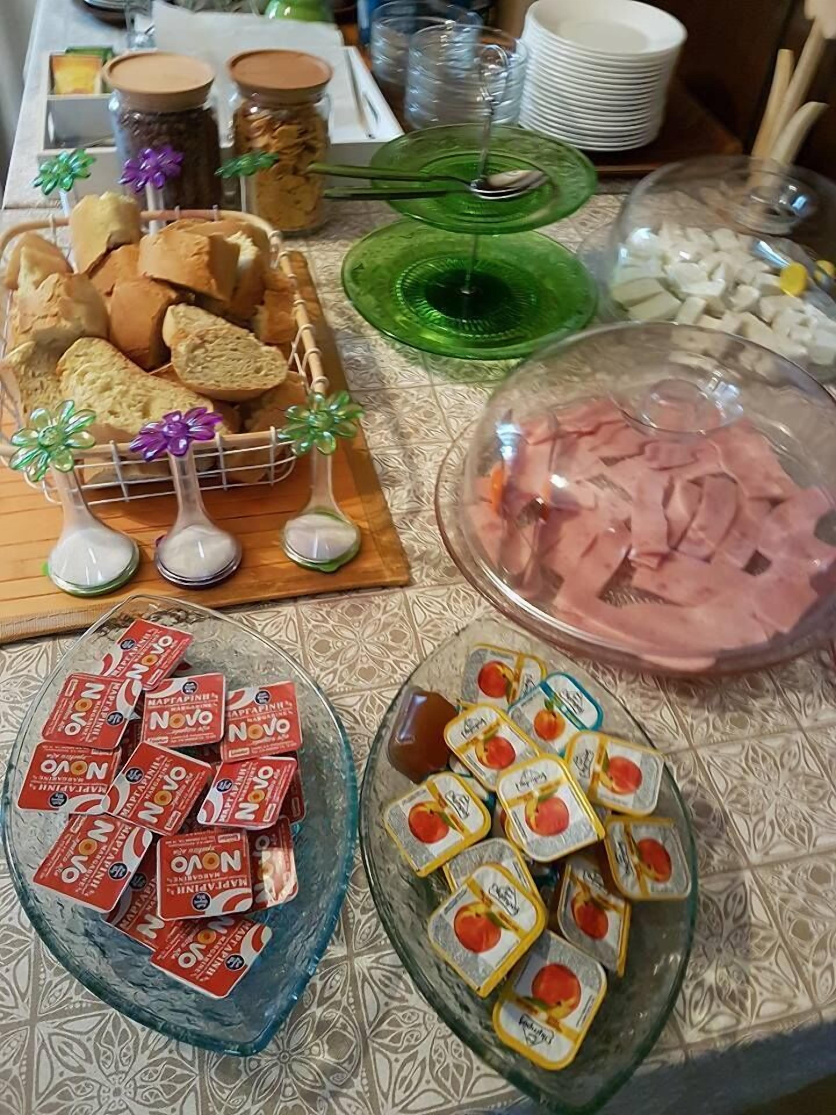 A buffet table with various food items including bread, ham, and packaged snacks.