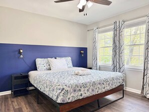 A bedroom with a bed, nightstands, a ceiling fan, and a window with curtains. - Charming Norcross Townhouse! Quiet & Convenient Stay (Norcross)
