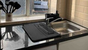 A kitchen with a window, a washing machine, and a sink.