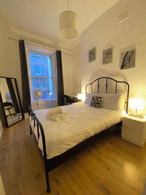 Relax in a stylishly designed room with a comfortable bed, bedside table, and large window.