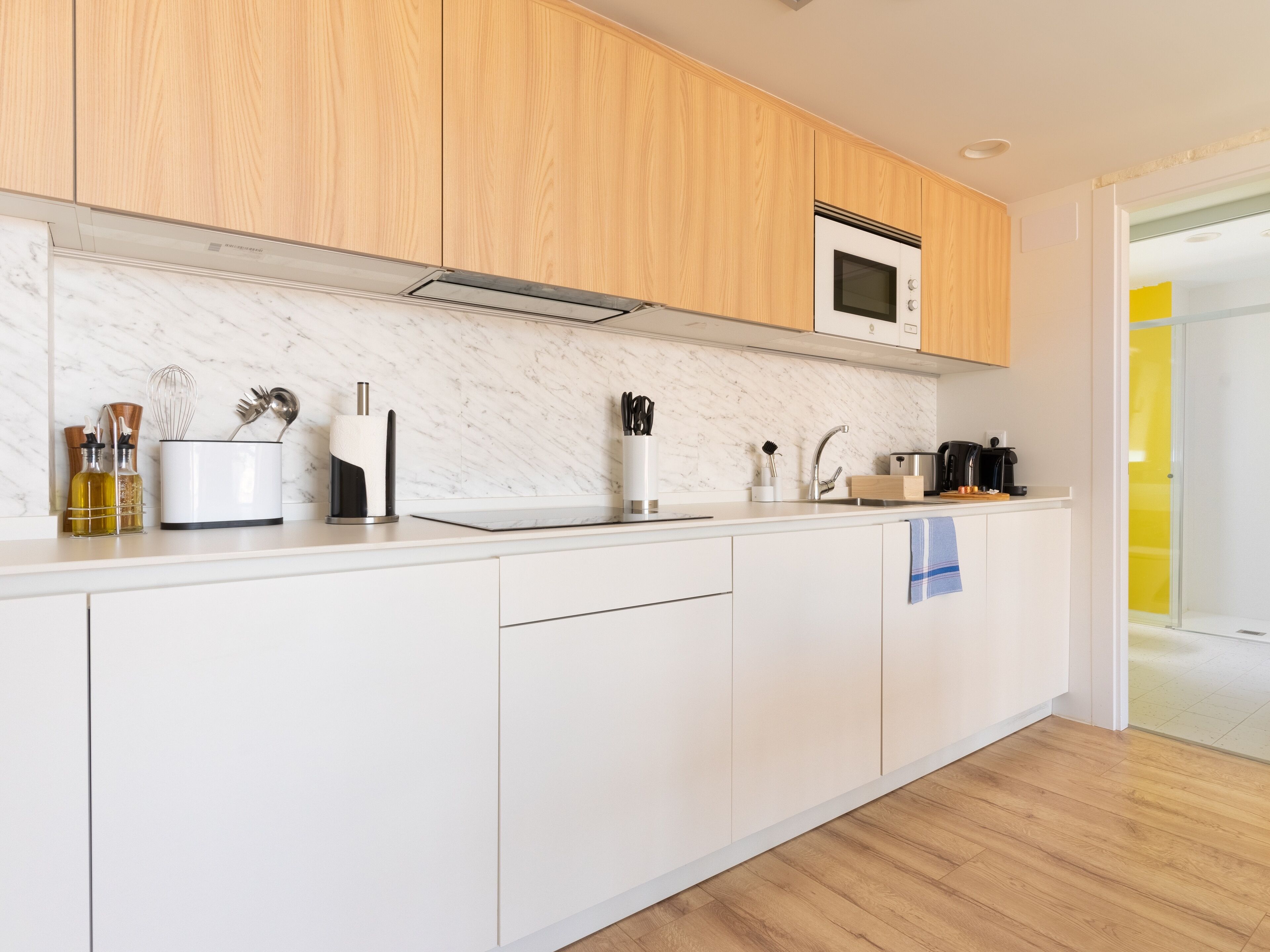 A modern kitchen with wooden cabinets, a microwave, and a sink.