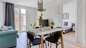 A modern living room with a dining area, a sofa, a table, and chairs. - Limehome Haro Calle de la Vega (Haro)