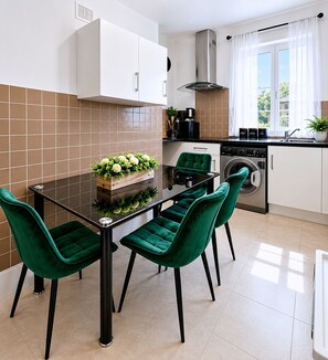 Une cuisine moderne avec une table à manger, des chaises et un lave-linge.