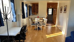 A modern living space with a dining area, kitchen, and a blue sofa. - Blue Skye: Downtown Getaway (Bishop)