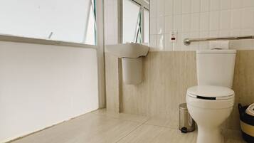 Un bagno moderno con il water, un lavandino e un cestino.