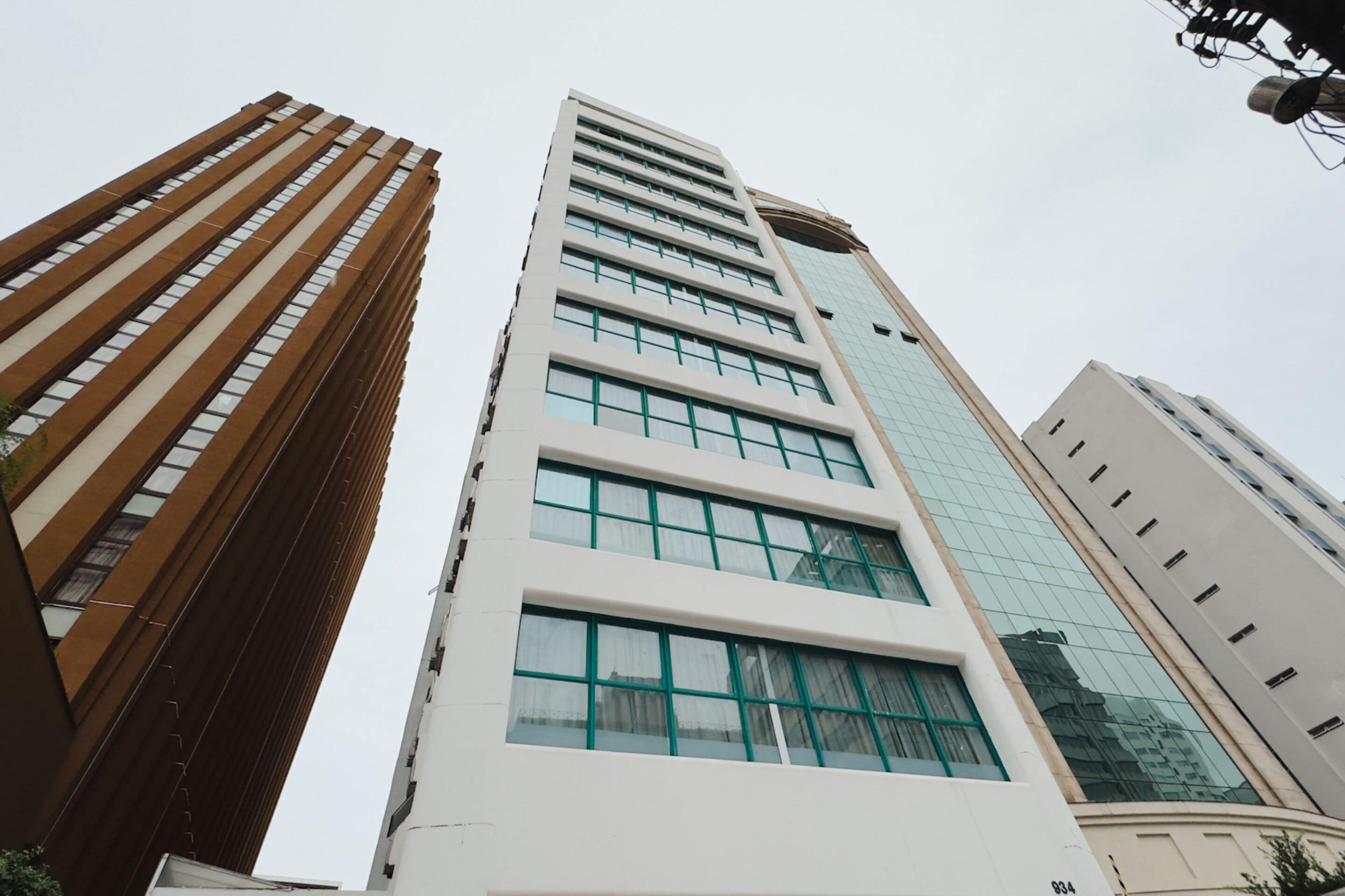 Un immeuble moderne et imposant, doté d’une façade blanche et de grandes fenêtres.