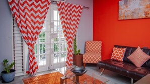 Ein Wohnzimmer mit einer Couch, einem Couchtisch und einer Zimmerpflanze.