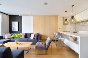 A modern living space with a sofa, armchair, and dining area.