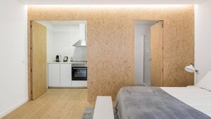 Une petite pièce comprenant un coin cuisine, un lit et une salle de bain.