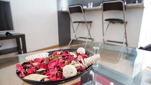 A dining table with a black bowl filled with dried flowers and herbs.