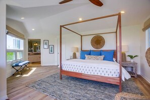 Relax in this serene bedroom with a four-poster canopy bed, patterned bedspread, and plush pillows.