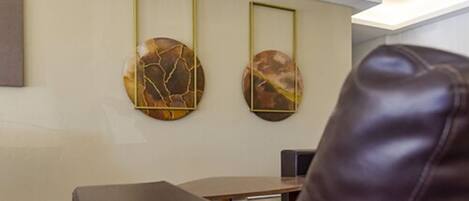 Un intérieur moderne agrémenté de deux œuvres d’art murales de forme circulaire, d’un canapé en cuir et d’une table en bois.