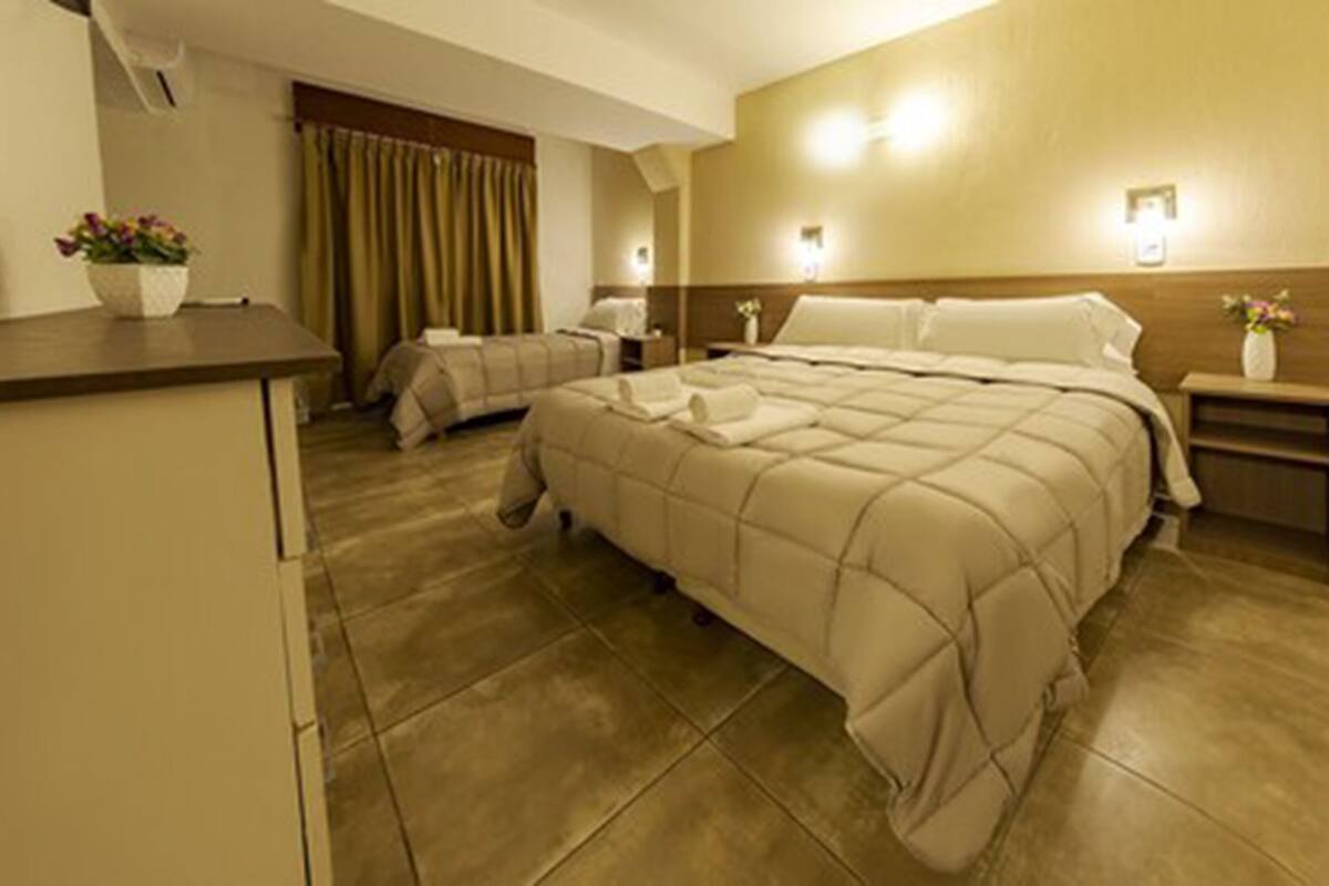 Ein Hotelzimmer mit einem großen Bett, einem Nachttisch, einem Schreibtisch und einem Sessel.