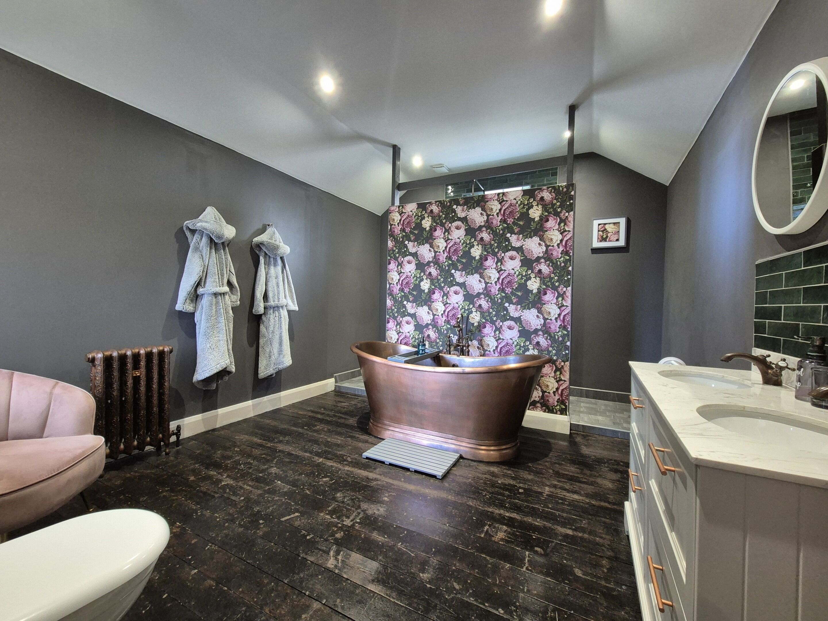 Une salle de bain moderne avec une grande baignoire, un meuble-lavabo avec un miroir et un radiateur.