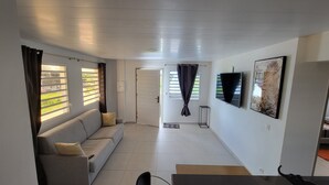 Una sala de estar moderna con un sofá, un televisor y un cuadro en la pared.