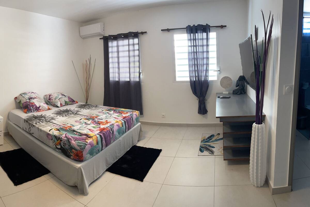 Une chambre à coucher comprenant un lit, des tables de chevet, un bureau et une chaise.