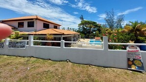 Hotel con piscina, zona vallada y cartel anunciando una promoción.
