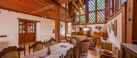 Un comedor espacioso con mobiliario de madera, una mesa grande y un techo alto con vigas a la vista.